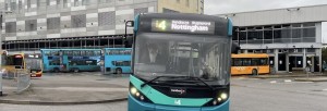 From street facing bust station, a blue single decker i4 bus departs Derby bus station roundabout.