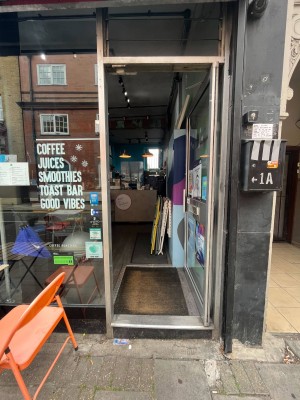 Glass and silver door straight ahead. Push to open. Handle on left side.