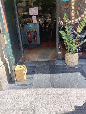 Closeup of entrance showing small slope into single door. Door propped open by brick