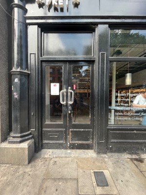 Double glass doors in black wooden frames. Push silver metal handle of right door from centre to open.