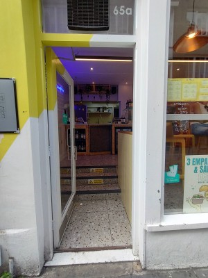 Glass door with handle on right. Push to open.