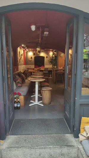 Glass doors with grey frame ahead. Push in centre to open. No door handles.