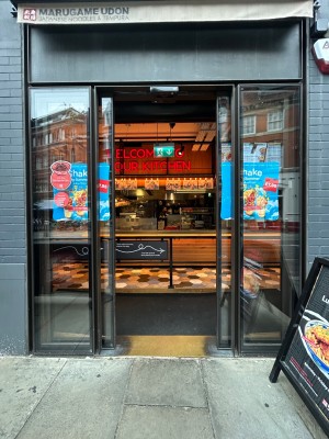 Sliding glass doors with black frame. Open automatically.