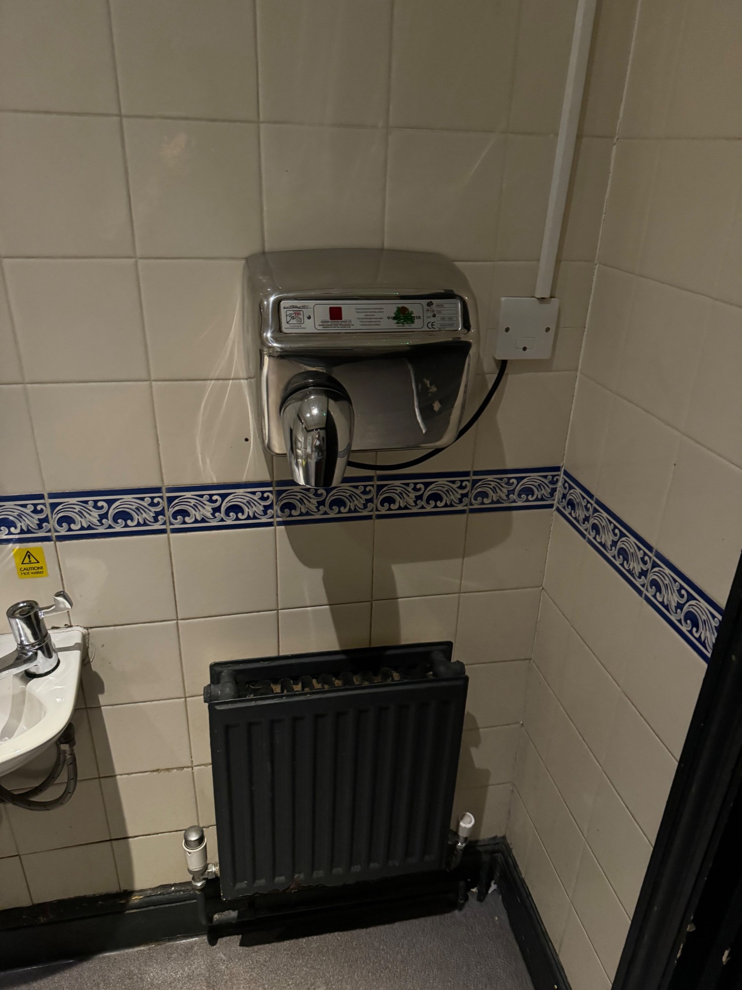 Hand dryer to the right of the sink
