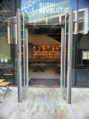 Glass doors with black frame. Silver vertical handles in centre. Pull to open.