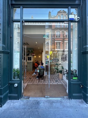 Double glass doors with black doorframe. Push silver vertical handles in middle to open.