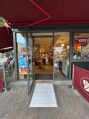 Glass door with grey frame. Silver vertical handle on right. Pull to open.