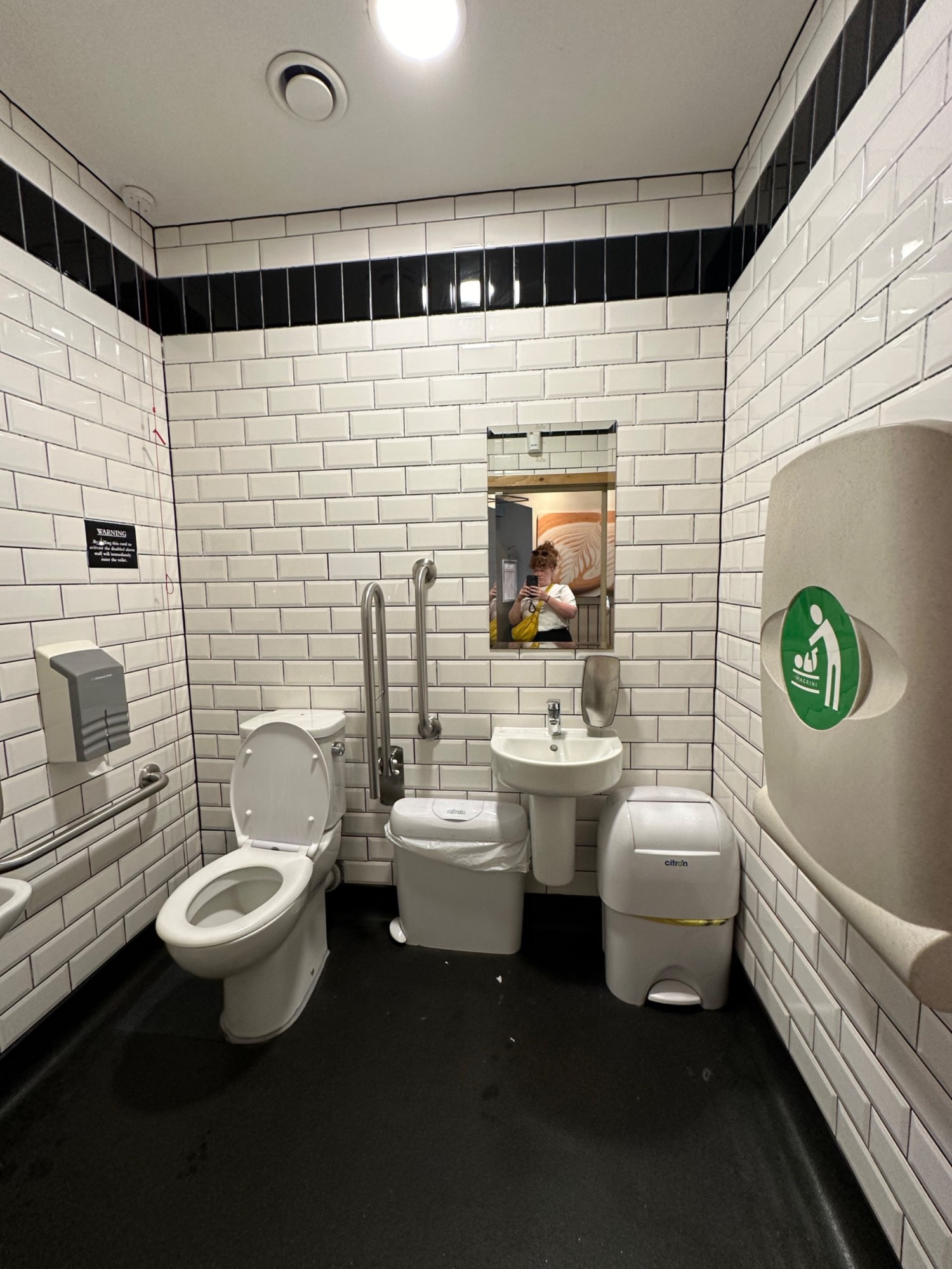 From door facing straight. Baby change on right. Sink ahead to right. Toilet ahead to left. Emergency cord to left of it.