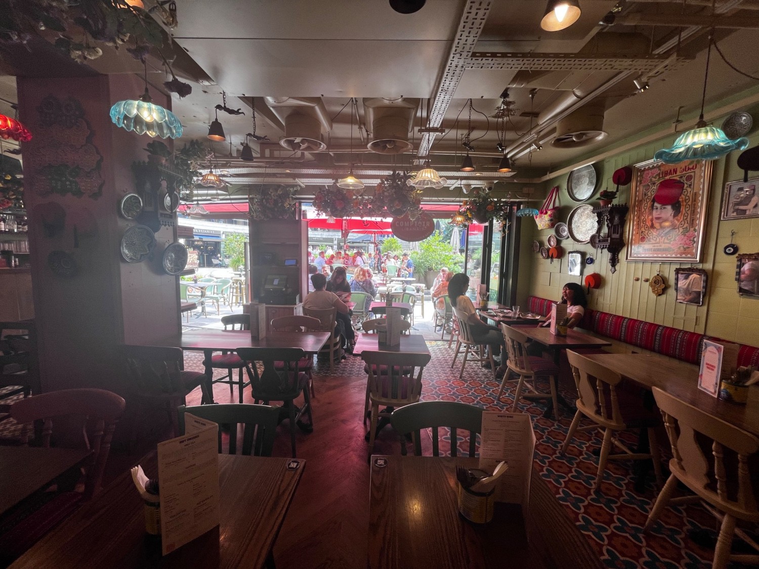 From half booth facing left. Chairs ahead. Path on right to outdoor seating. Half booth along right wall.