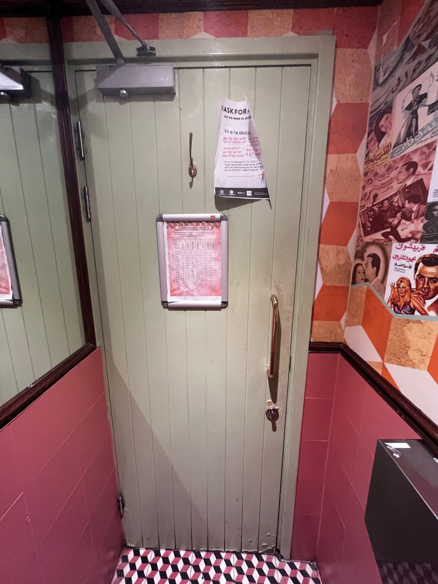 From front of toilet facing straight. Pull gold vertical metal handle to open. Turning lock mechanism below handle.