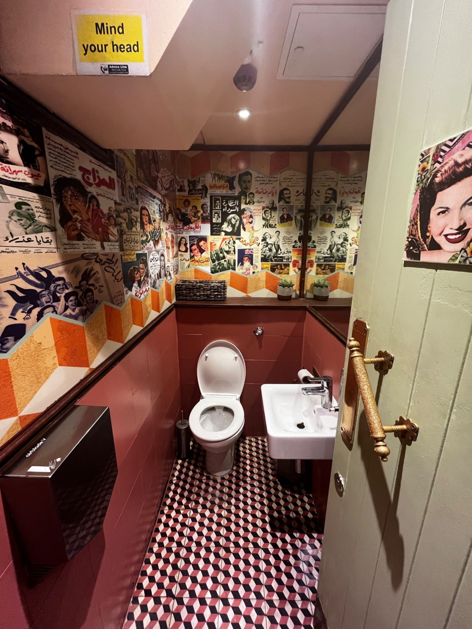 From doorway facing straight. Toilet ahead at back. Sink to the right.
