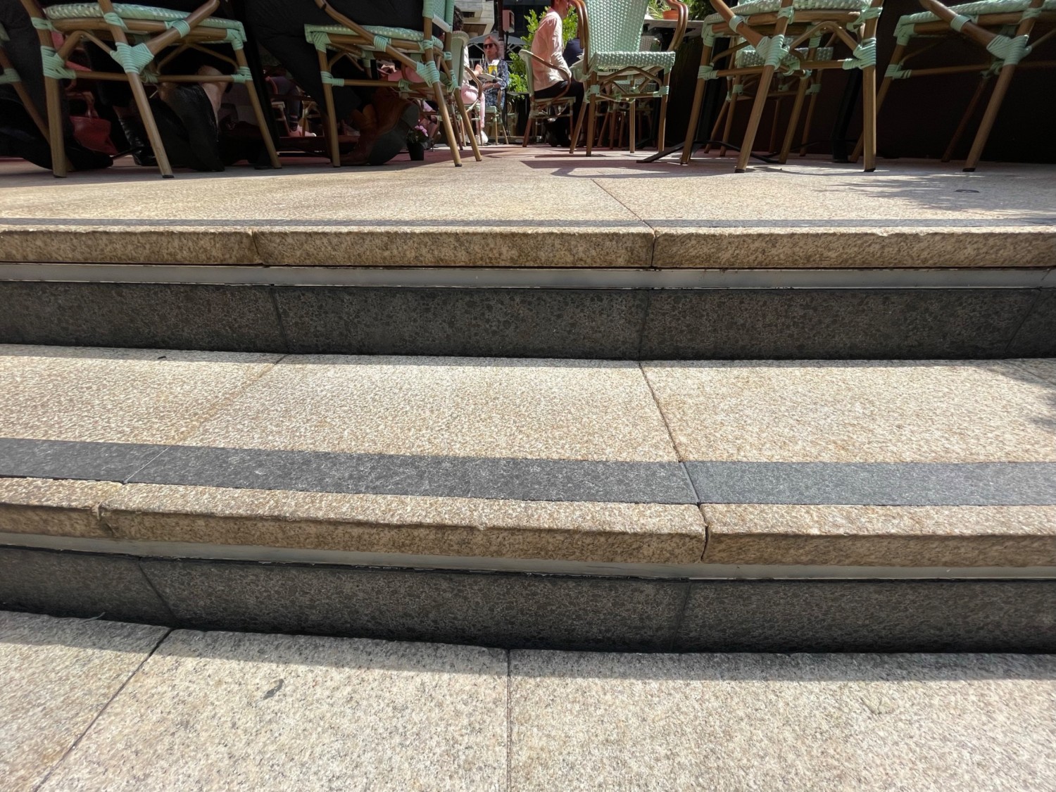 From outside entrance, facing behind. Two concrete steps leading up to outdoor seating area.
