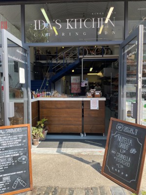 Glass doors with grey frame. Grey handles in centre. Pull to open. Menu boards to left and right of doors.