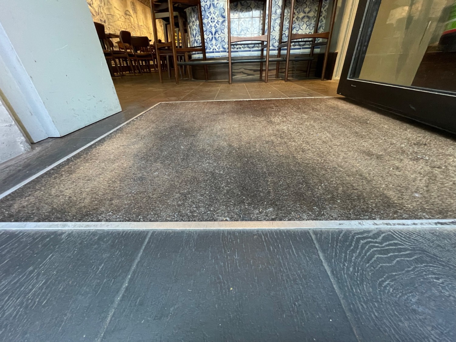 Second metal bump immediately after doorway. Carpeted area ahead of bump.