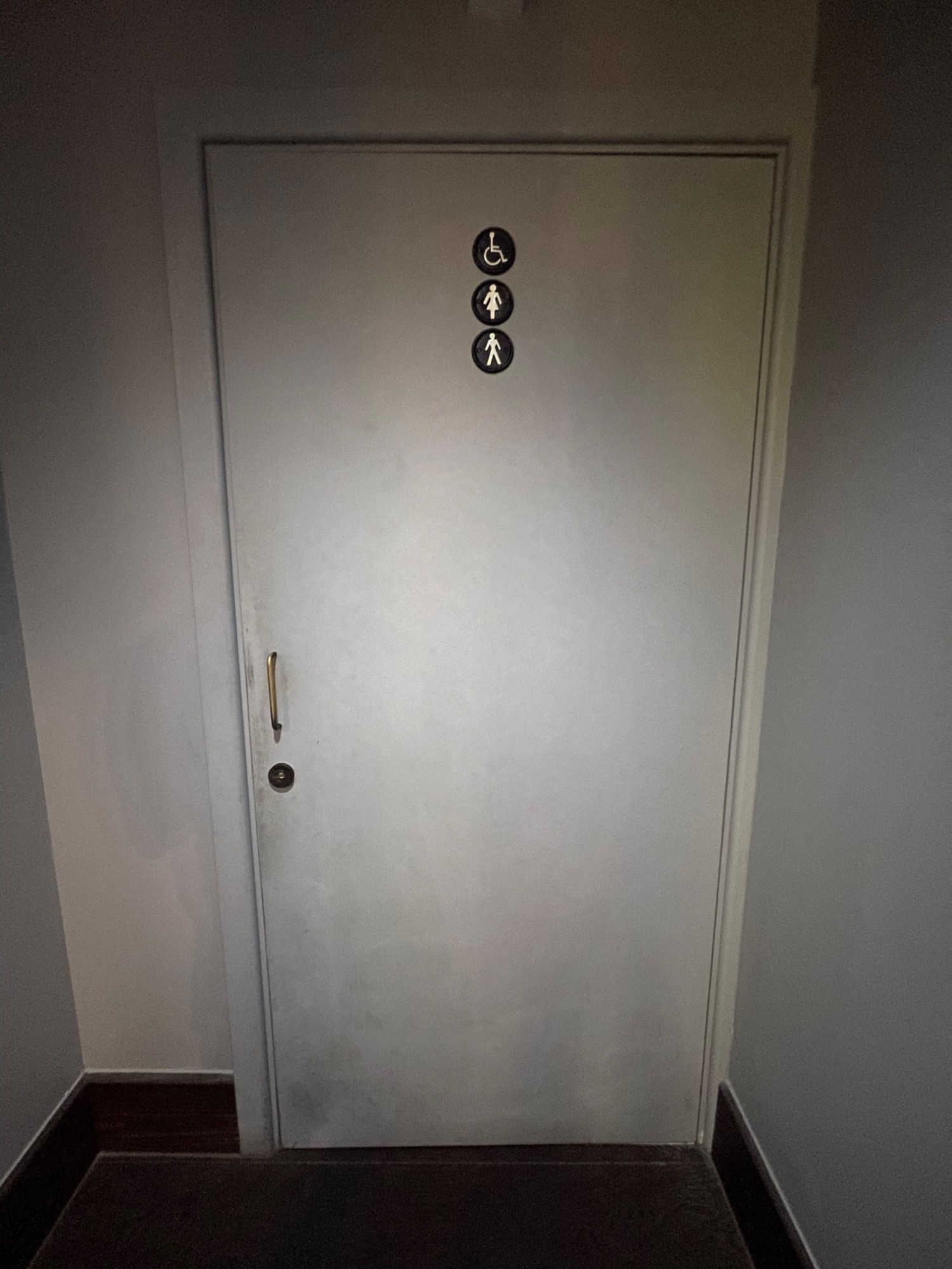 From end of path, facing straight. Toilet door ahead. Pull brass handle on left to open.