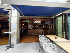 Glass doors with brown frame, silver hand in middle. Pull to open.
