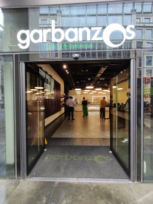 Glass door with black frame. Push from middle to open.