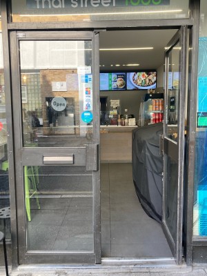Double glass doors with metal frame. Push open via handles on center.
