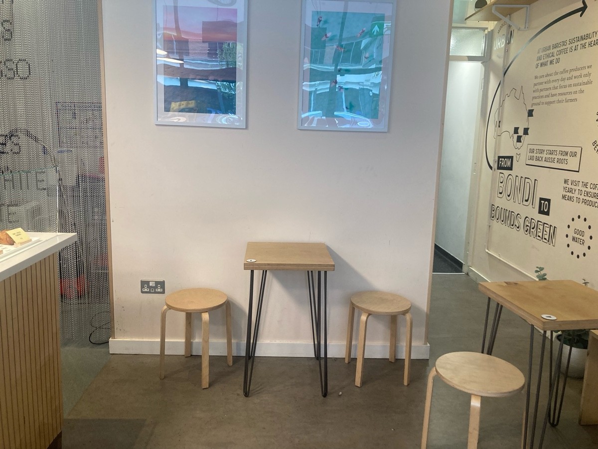 From beginning of counter, facing right. Path ahead. Counter along left. Table and stools on back. Tables and stools along right.