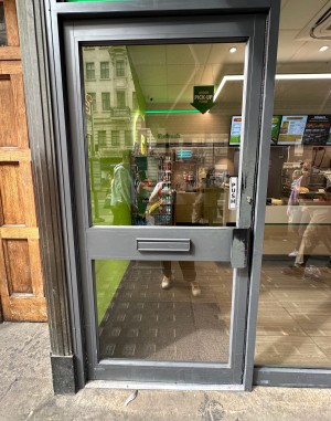 Grey and glass panelled door. Grey handle on right, push to open.