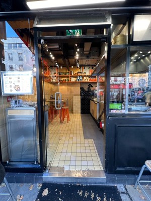 Glass door with silver vertical handle on right, push to open.