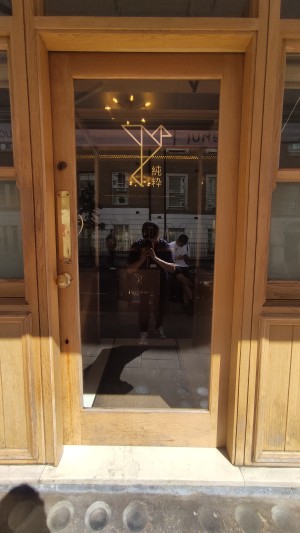 Glass door with wooden frames ahead. Push via handle on left to open.