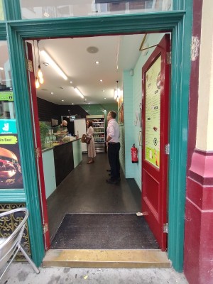Red doors with green frame. Gold handle in middle. Push to open.