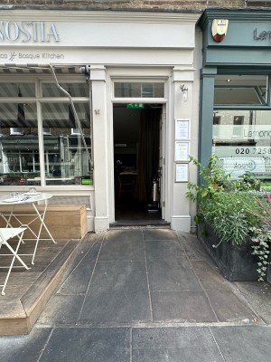 Built in ramp followed by step to entrance. White glass paneled door ahead.