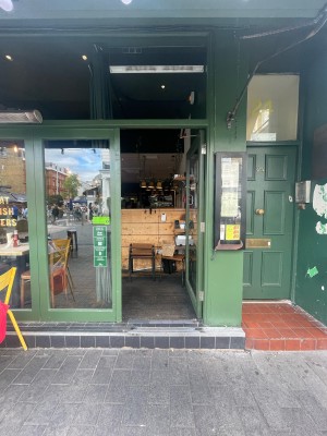 Double glass doors with green frame. Push green metal handle from centre to open.