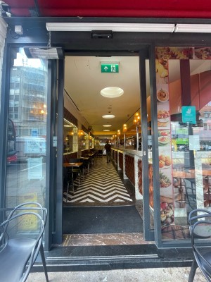 Glass sliding doors with black frame. Opens from centre. Seating to left and right of entrance.