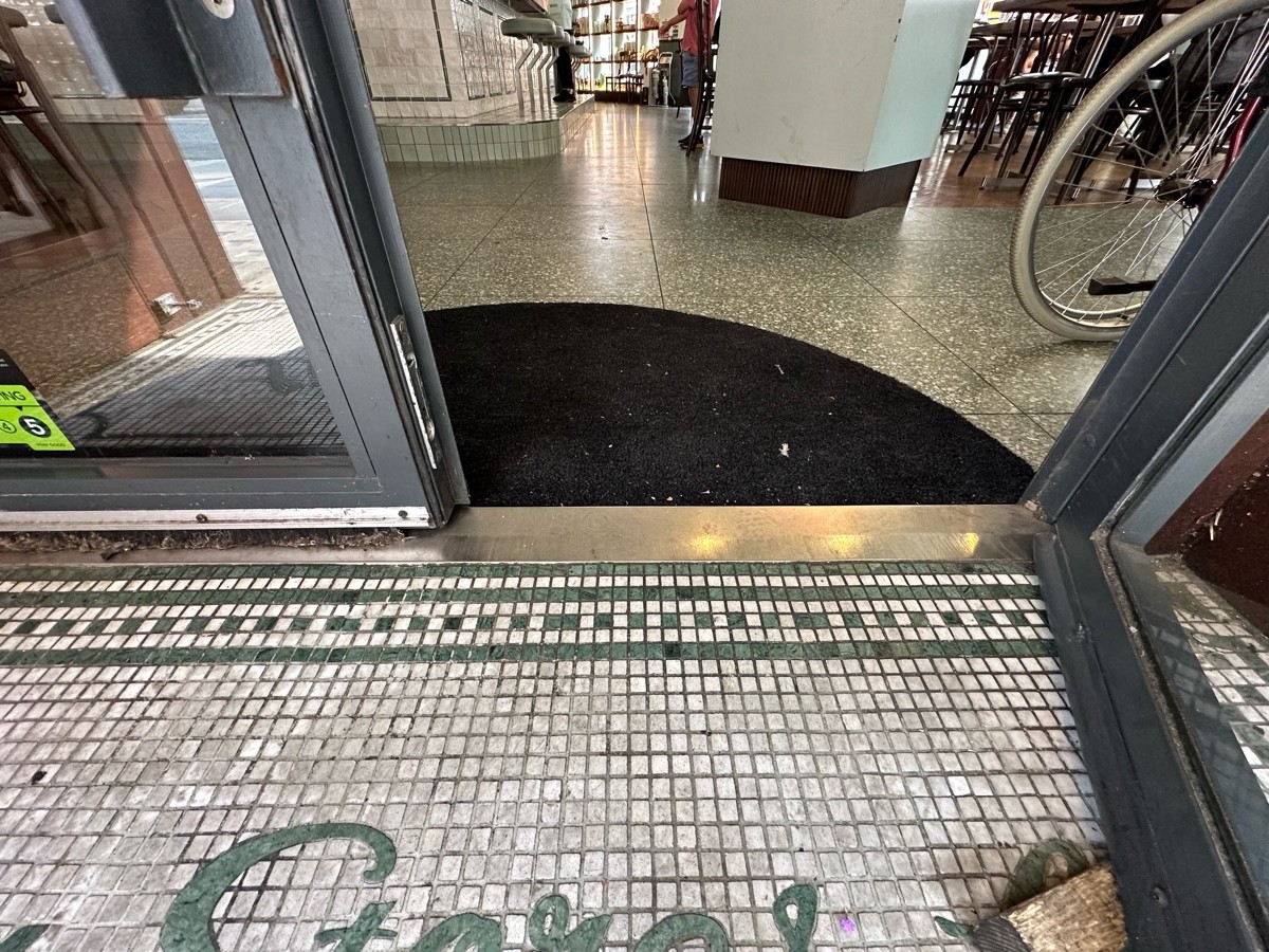 Small bump at foot of doors, followed by doormat.