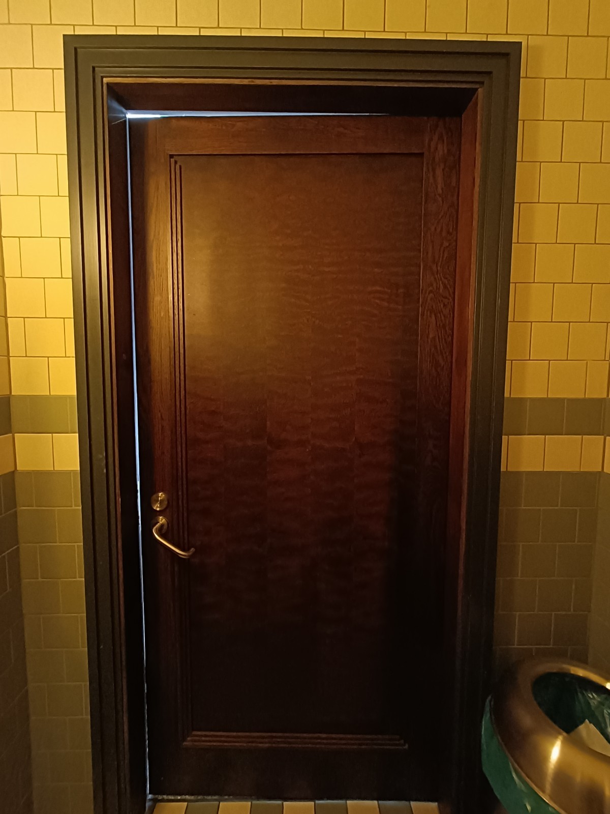 Back of bathroom door. Golden handle on left.
