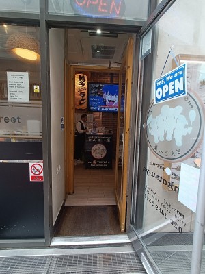 Glass door with grey frame. Silver vertical handle on left. Pull to open.