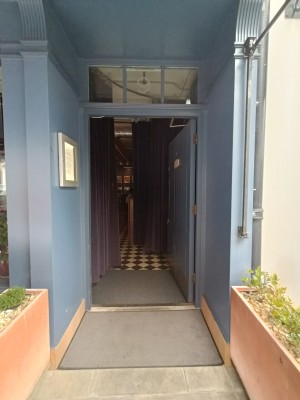 Blue door with golden pad on left. Push to open.