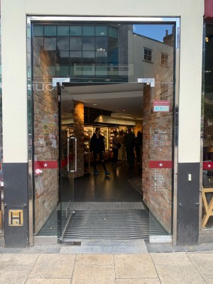 Glass door ahead. Push from vertical metal handle on right to open.