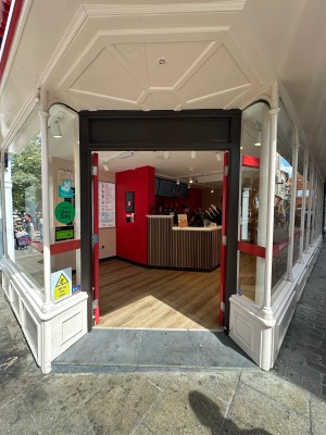Glass doors with red frames. Push from centre to open.
