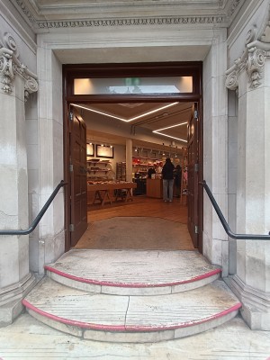 Brown doors with knobs in the middle. Push to open. Black handrails on both sides.