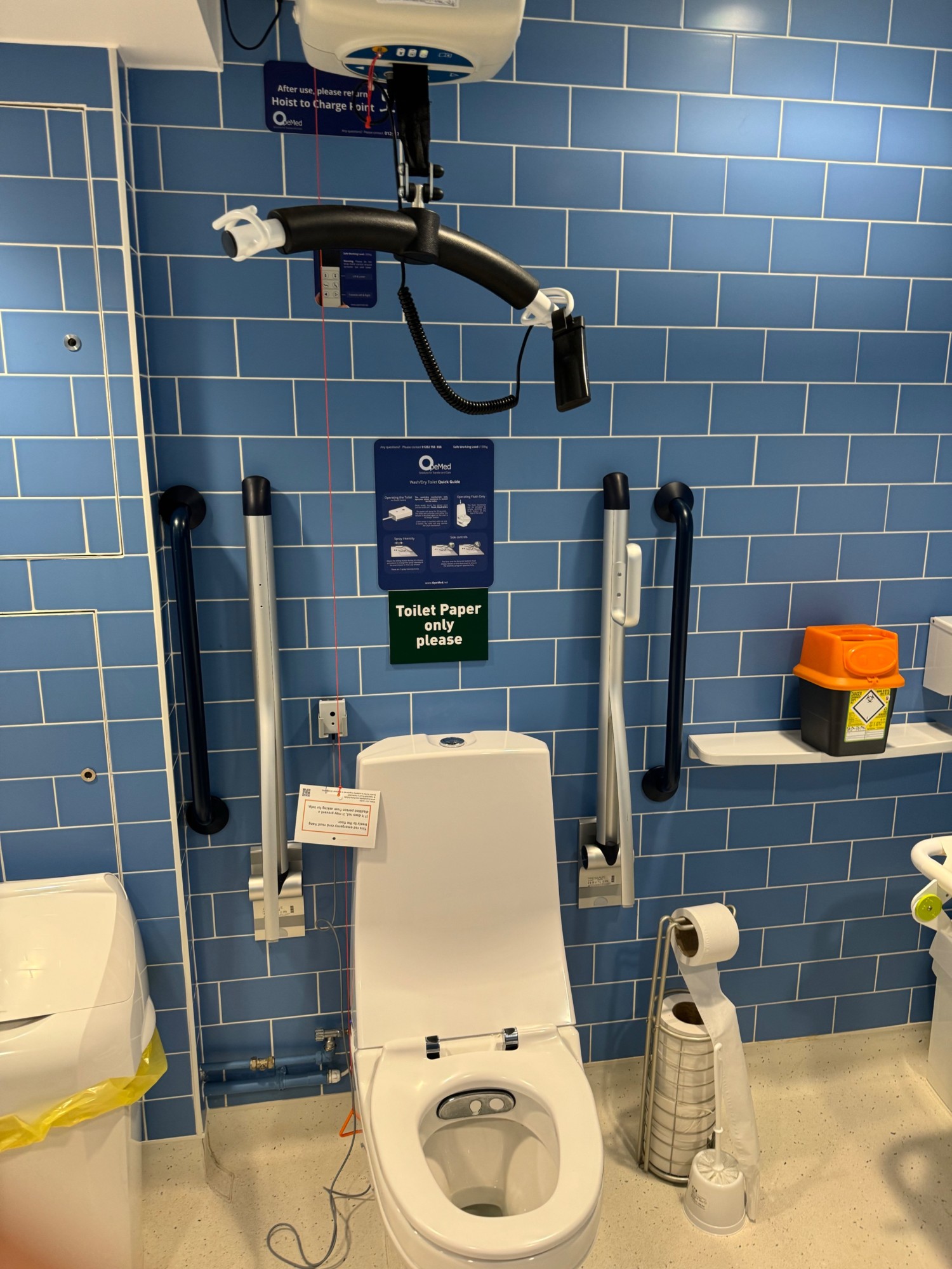 Toilet with beday and no touch flush grab rails bot sides and both side transfer hoist charge is above the toilet