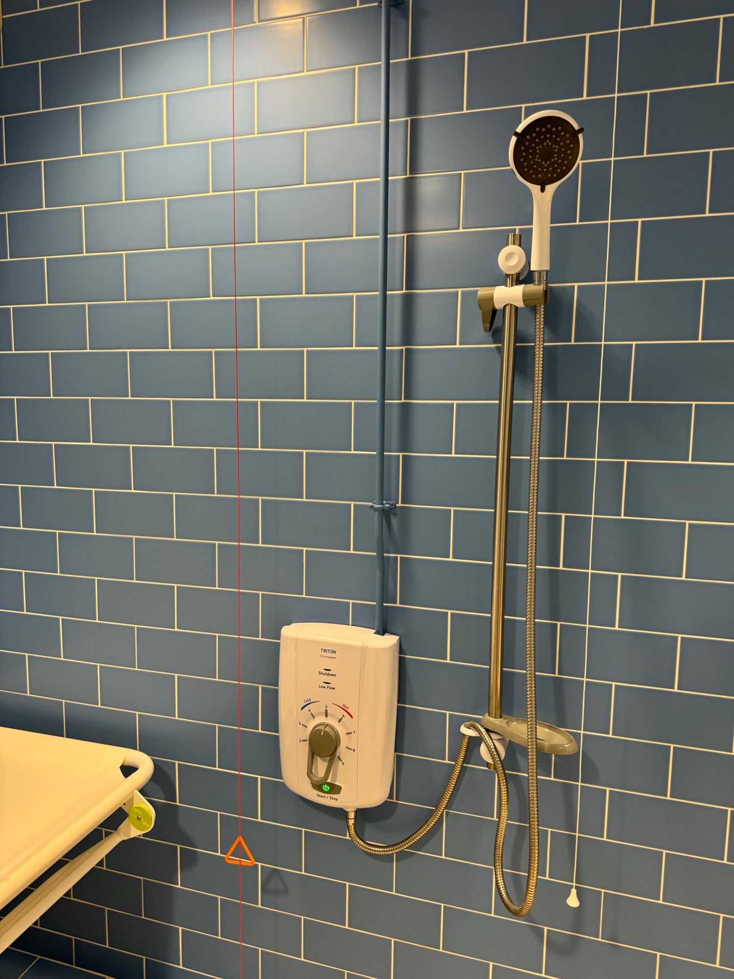 Shower next to change bench with drain in the floor