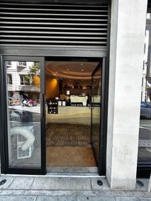 Single glass door, with black metallic frames. Black handle on mid left. Push to open.