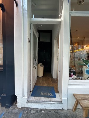 Preceding single white wooden door with large glass panel. Push from right to open.