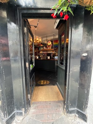 Single glass door in black wooden frame. Push gold metal panel from right to open.