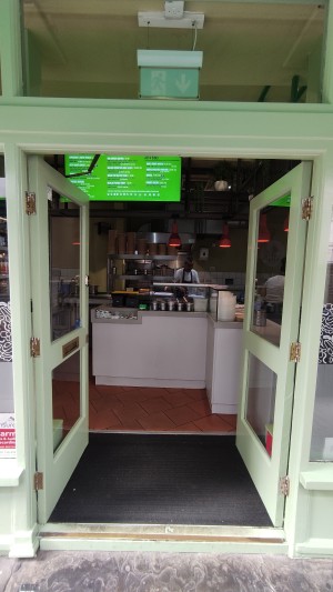 Glass doors with green doorframes ahead. Push in centre to open. No handle.
