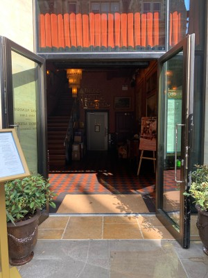 Double glass doors with black metal frame ahead. Pull from vertical metal handles in centre to open.