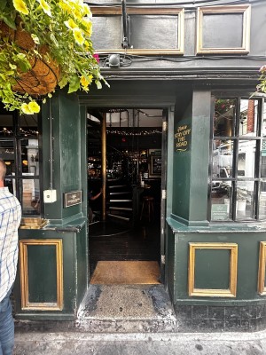 Glass door with black frame. Golden handle on left. Push to open