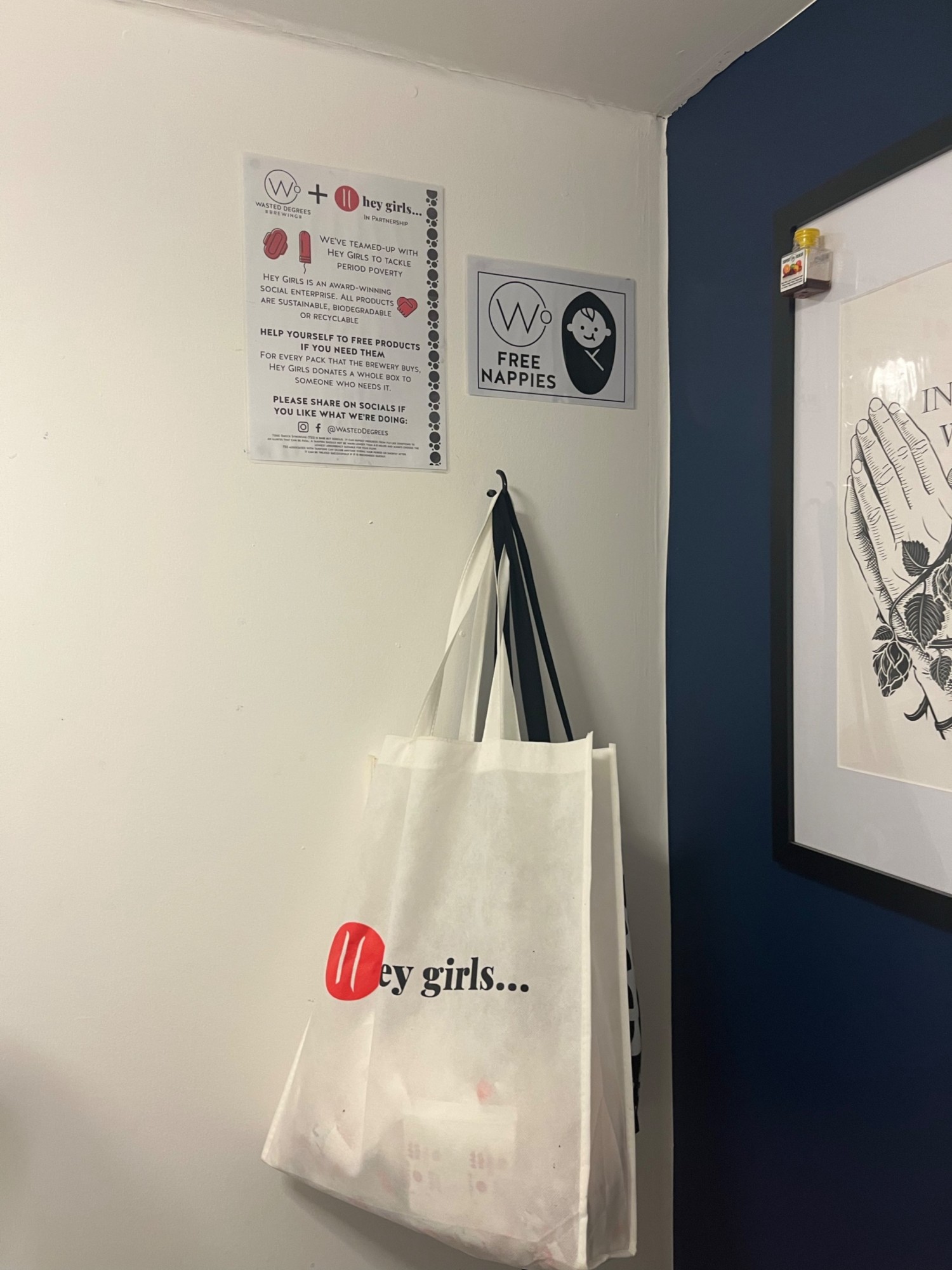 A bag of free period products is hung on the back wall on the right.