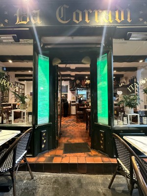 Glass door with black frame. Gold vertical handle on right, push to open.