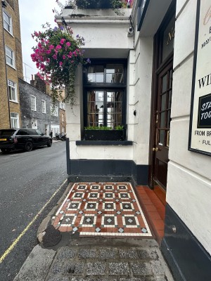 From paving stones to right of entrance, facing straight. Tiled area ahead. Entrance ahead on right.
