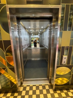 From ground level, facing lift. Control panel on right. Lift opens outwards from centre.