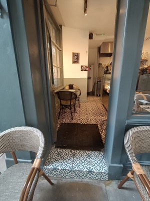 Glass door with grey frame. Golden metal handle on right. Push to open.